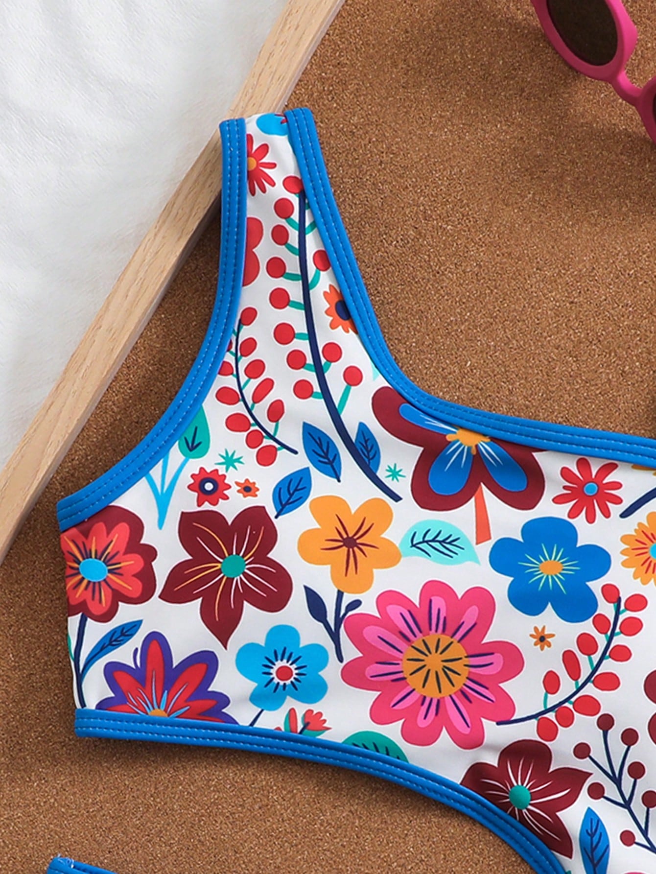 Tween girls one-piece swimsuit featuring an asymmetric neckline, pendant decor, plain design, wireless bra, high-cut bottom, and medium-stretch fabric.