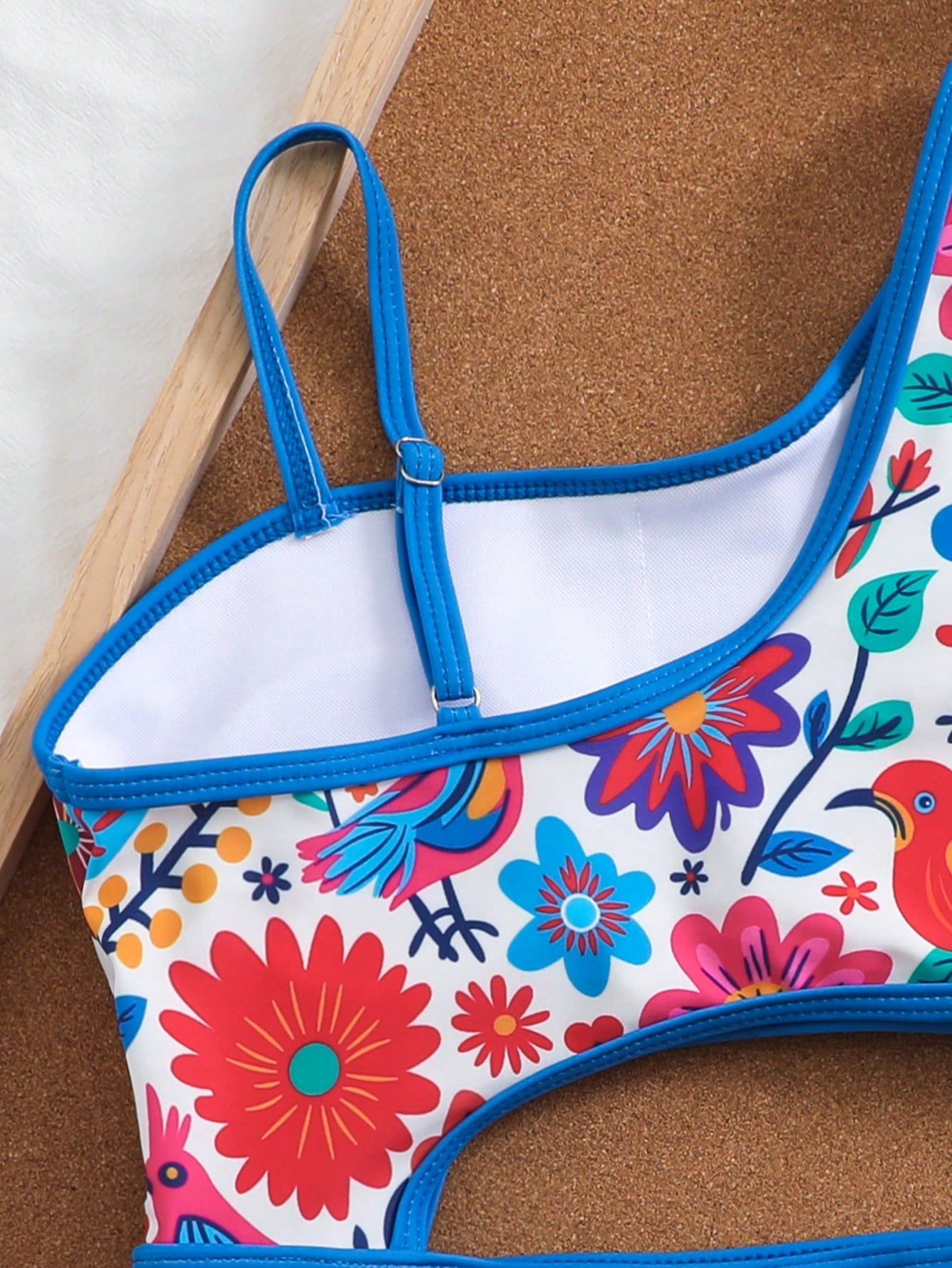 Tween girls one-piece swimsuit featuring an asymmetric neckline, pendant decor, plain design, wireless bra, high-cut bottom, and medium-stretch fabric.