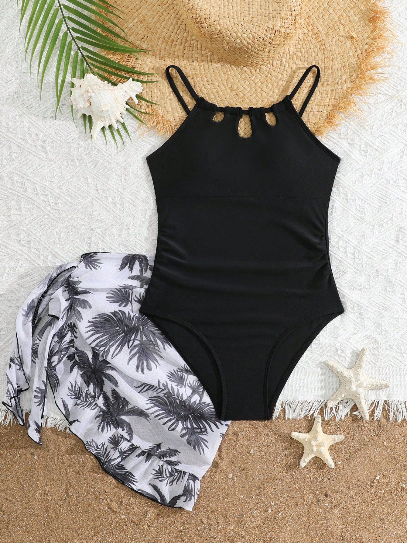 Girls black and white one-piece swimsuit set with cut-out detail, spaghetti straps, sleeveless fitted design, and matching skirt bottom for vacation swimwear.