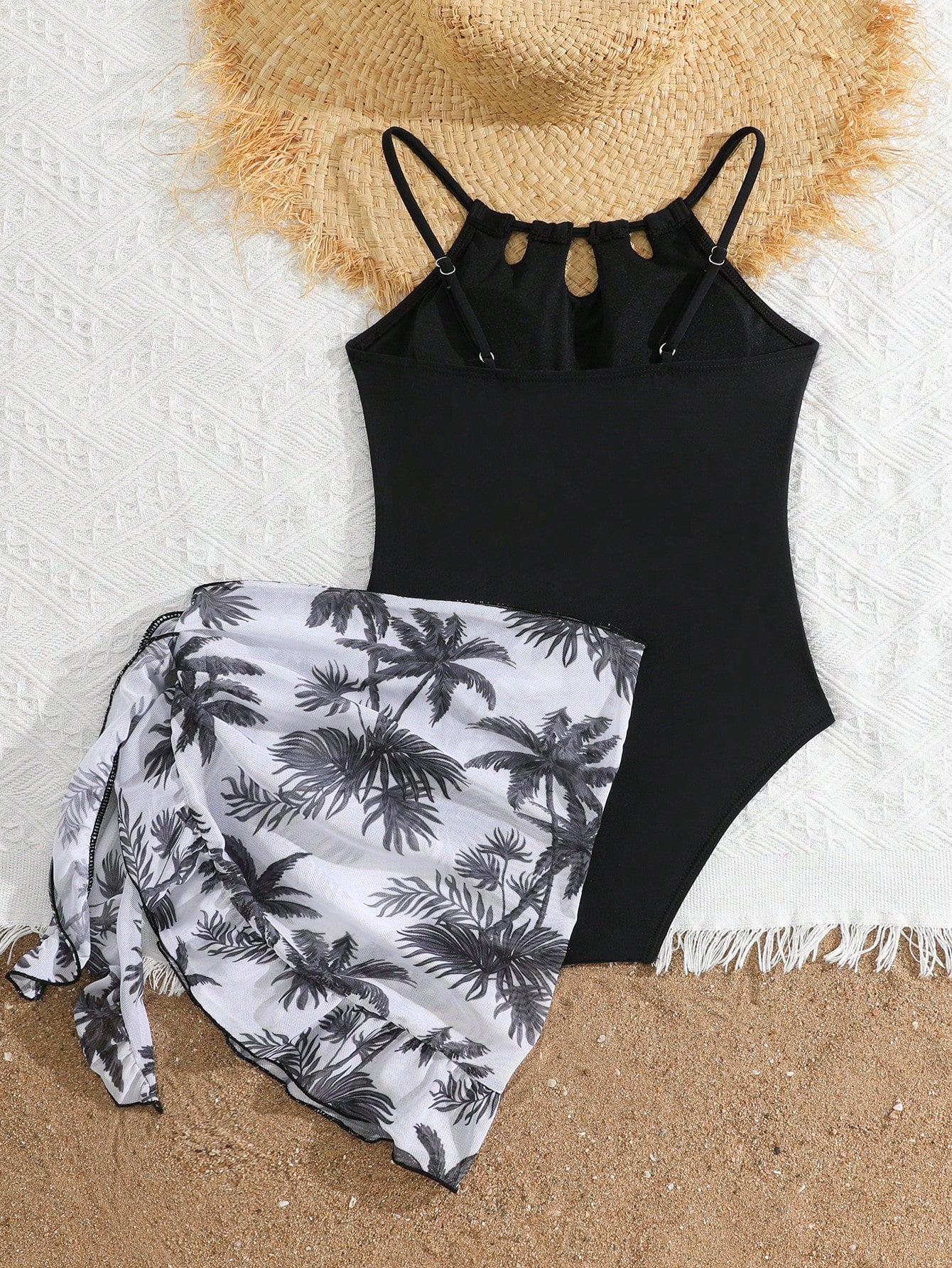 Girls black and white one-piece swimsuit set with cut-out detail, spaghetti straps, sleeveless fitted design, and matching skirt bottom for vacation swimwear.