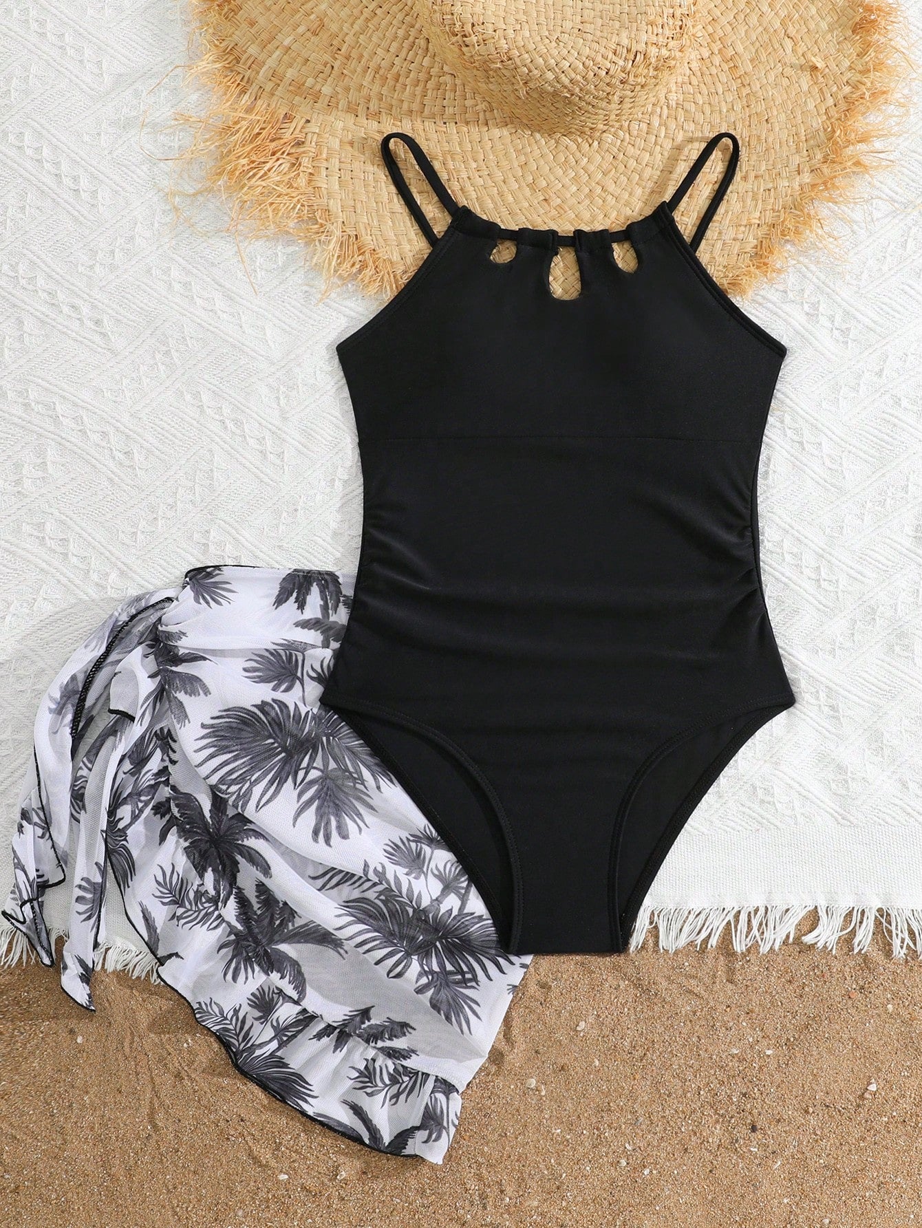 Girls black and white one-piece swimsuit set with cut-out detail, spaghetti straps, sleeveless fitted design, and matching skirt bottom for vacation swimwear.