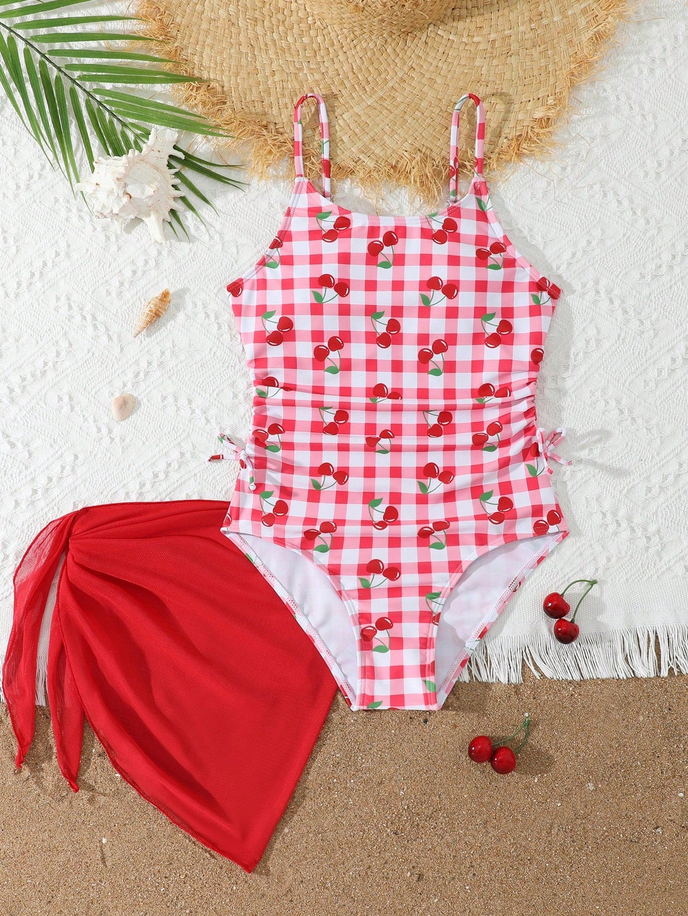 Tween girls 2-piece swimsuit in black with pink floral print, featuring spaghetti straps, bow decor, mesh detail, and a skirted mid-waist bottom. Sleeveless vacation-style swim set with medium-stretch fabric.