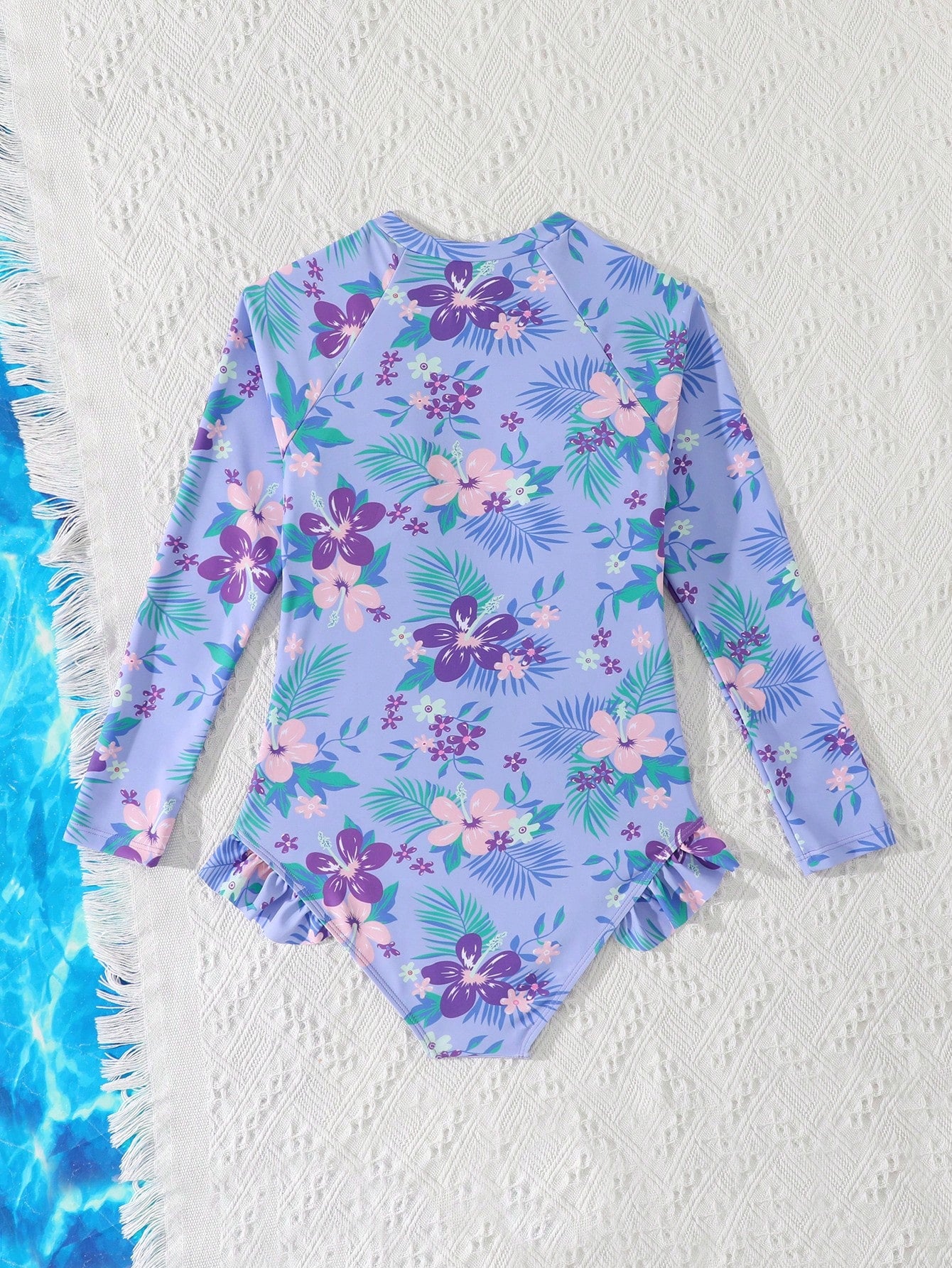 Girls one-piece swimsuit in blue with all-over leopard leaf print, ruffle detail, zipper front, high neck, and lined body for swimming and vacation.