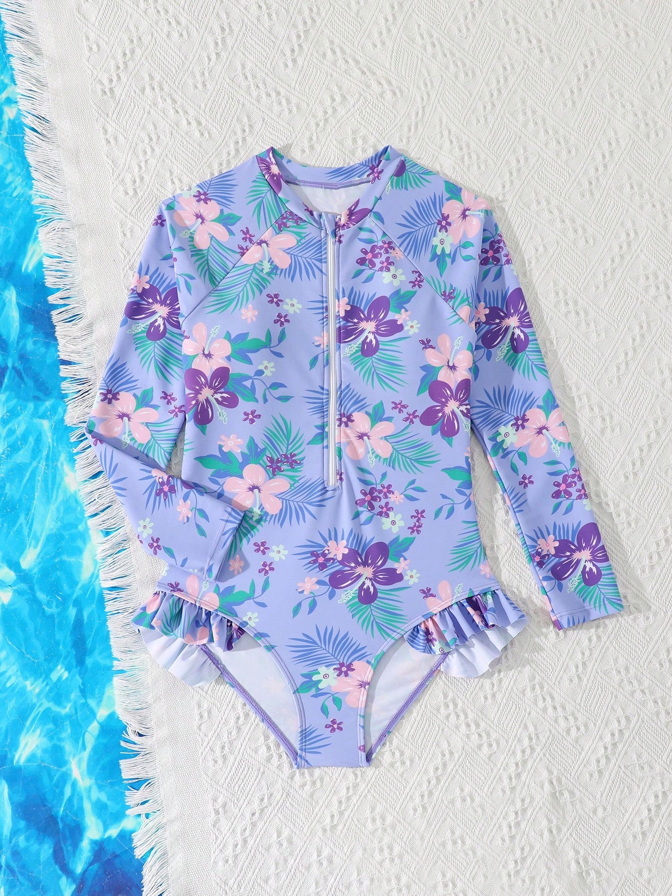 Girls one-piece swimsuit in blue with all-over leopard leaf print, ruffle detail, zipper front, high neck, and lined body for swimming and vacation.