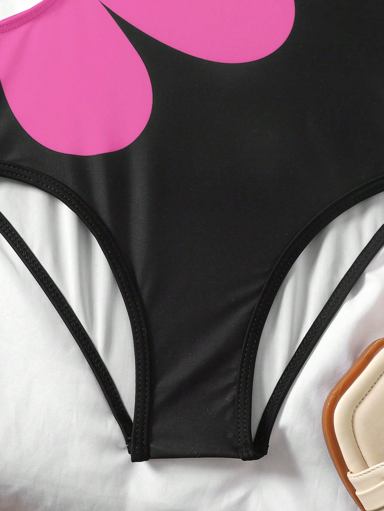 Tween girls' black and white one-piece swimsuit with striped patchwork design, scoop neck, asymmetrical cut-out detail, and fitted vacation swimwear style.