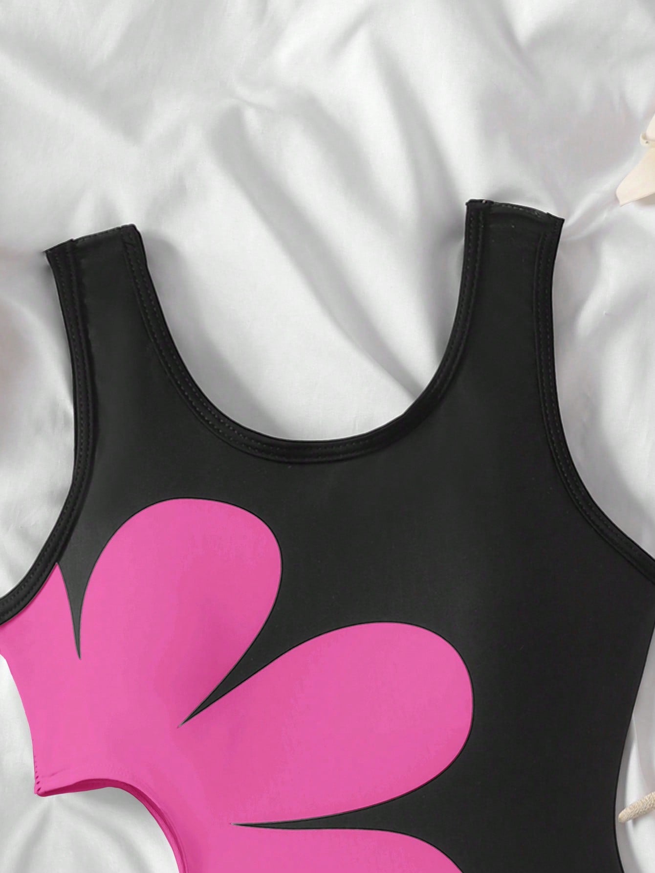 Tween girls' black and white one-piece swimsuit with striped patchwork design, scoop neck, asymmetrical cut-out detail, and fitted vacation swimwear style.