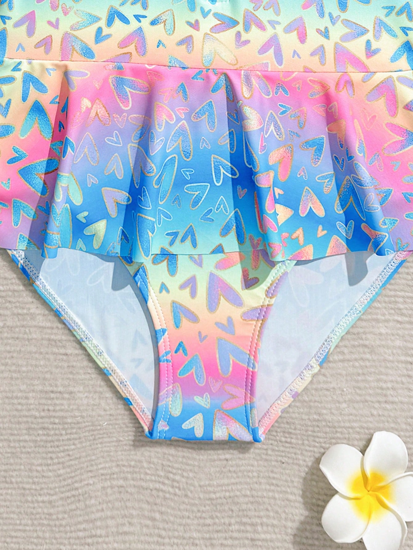 Purple tween girls one-piece swimsuit with graphic striped print, ruffle detail, round neck, and zipper closure for swimming and vacation wear