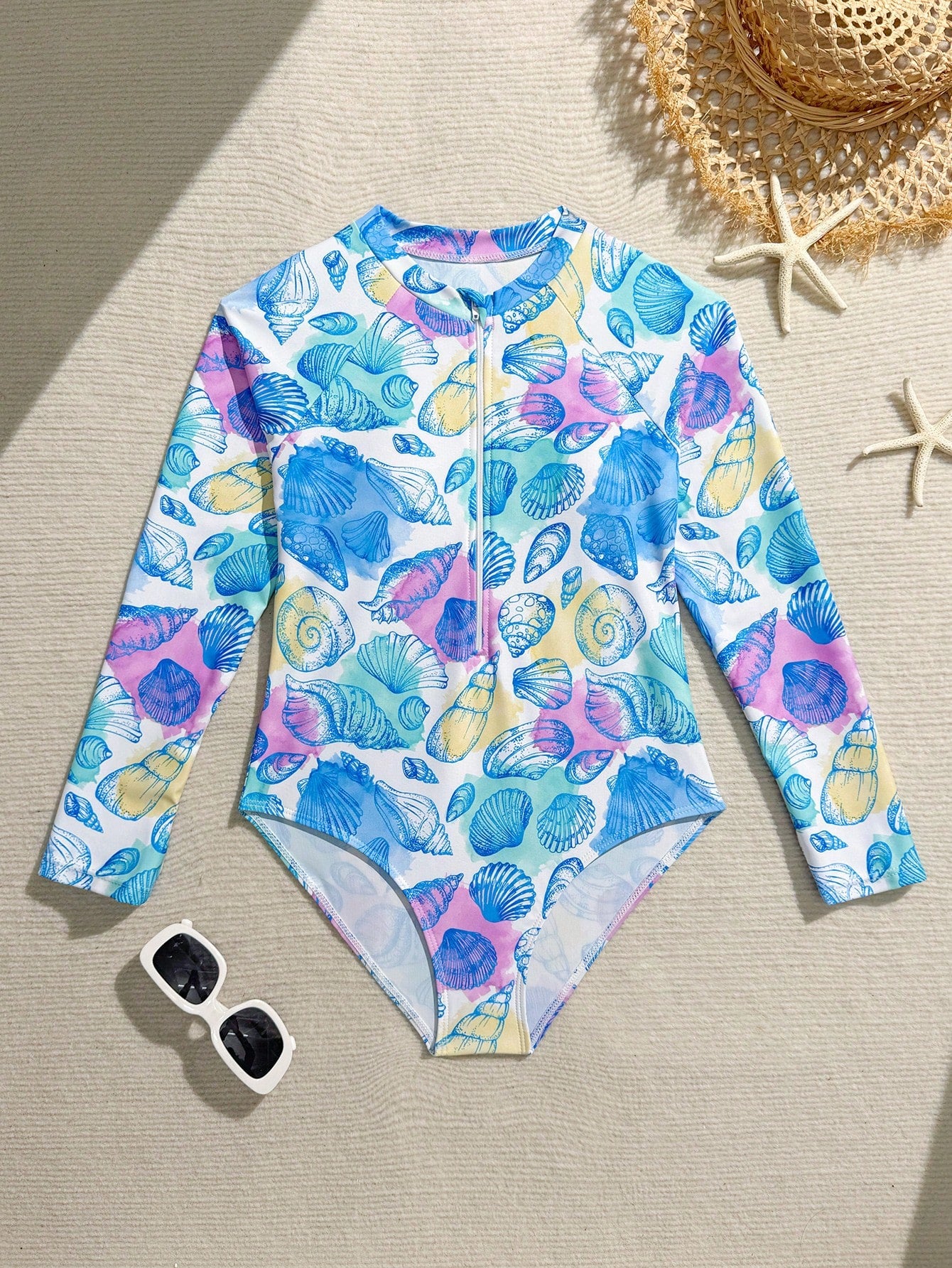 Girls one-piece swimsuit in blue with all-over leopard leaf print, ruffle detail, zipper front, high neck, and lined body for swimming and vacation.