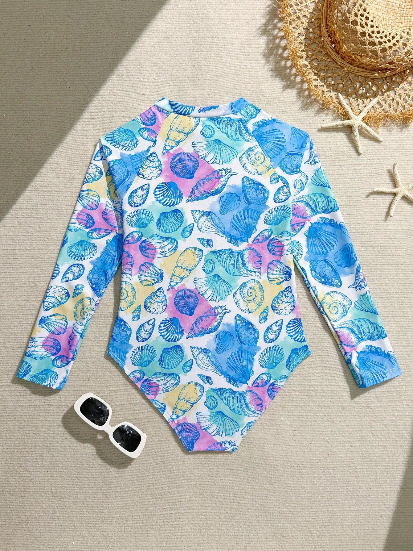 Girls one-piece swimsuit in blue with all-over leopard leaf print, ruffle detail, zipper front, high neck, and lined body for swimming and vacation.