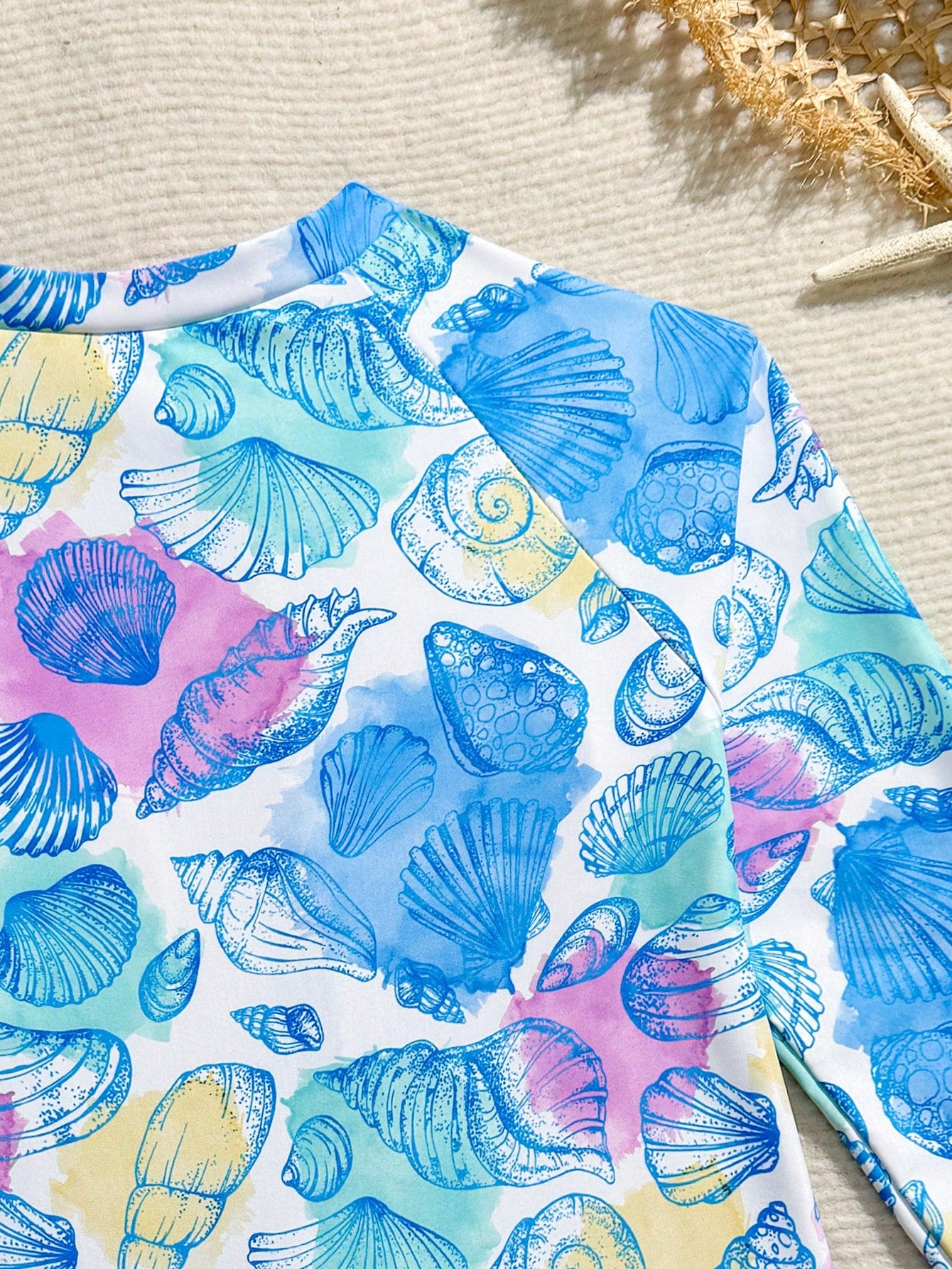 Girls one-piece swimsuit in blue with all-over leopard leaf print, ruffle detail, zipper front, high neck, and lined body for swimming and vacation.