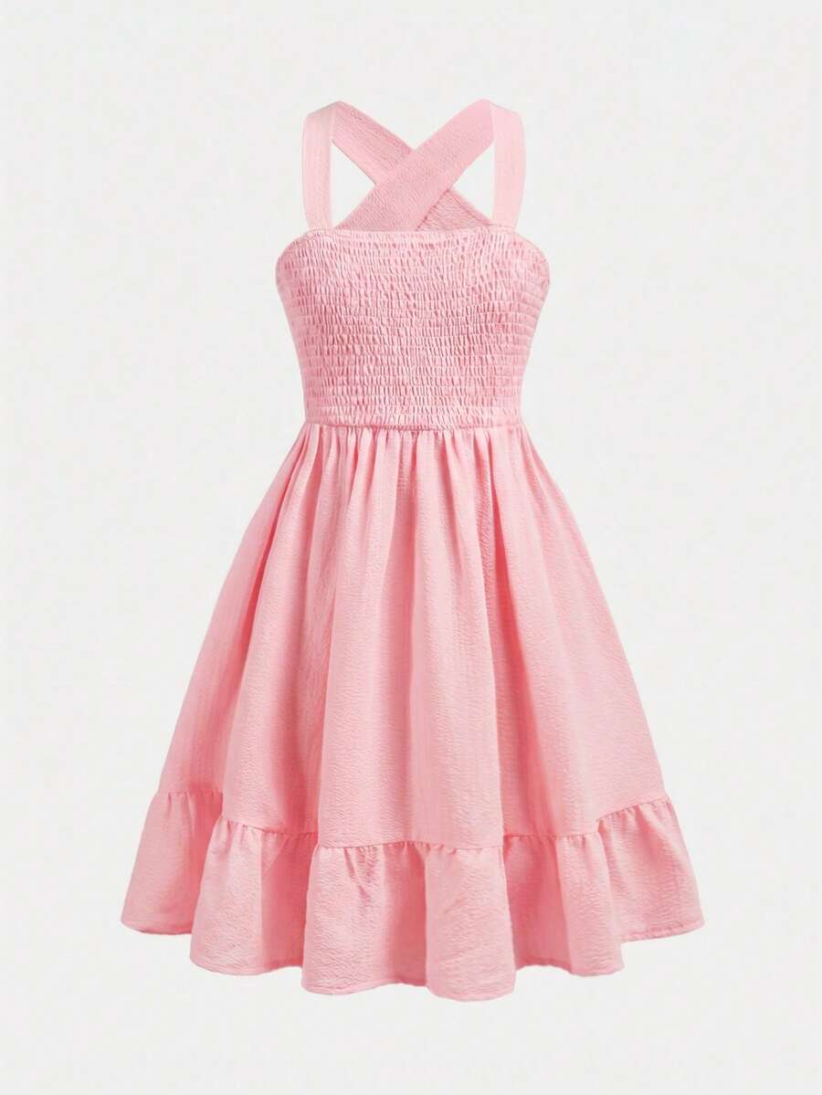 Pink sleeveless tween girls vacation dress with all-over fruit and vegetable print, strap neckline, belted high waist, cut-out detail, and flared ruffle hem.