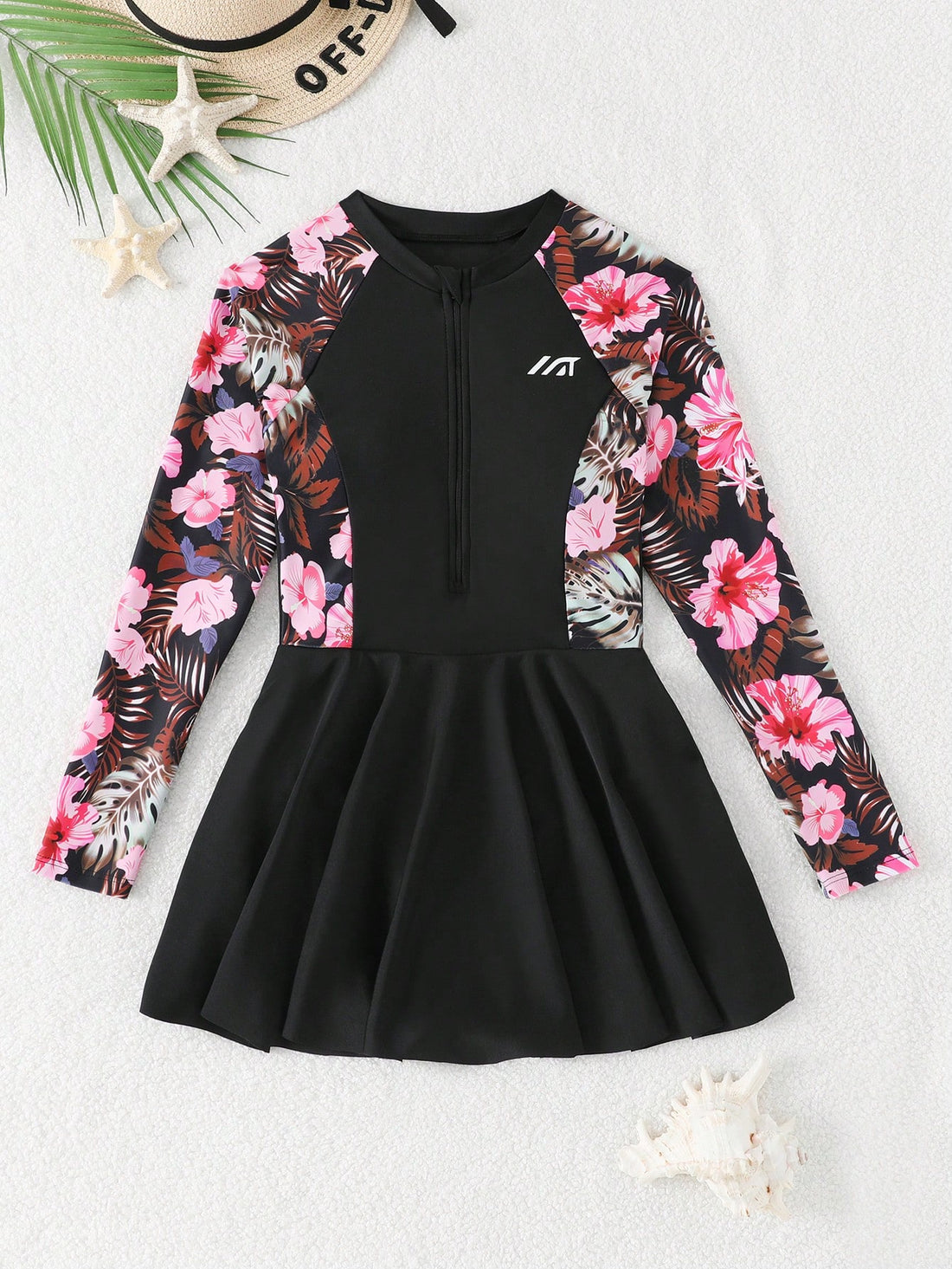 Tween girls one-piece swimsuit in black floral pattern with long sleeves, high neck, front zipper, and a skirt-style bottom.