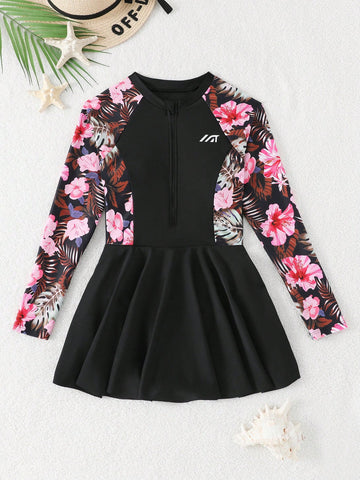 Tween girls one-piece swimsuit in black floral pattern with long sleeves, high neck, front zipper, and a skirt-style bottom.