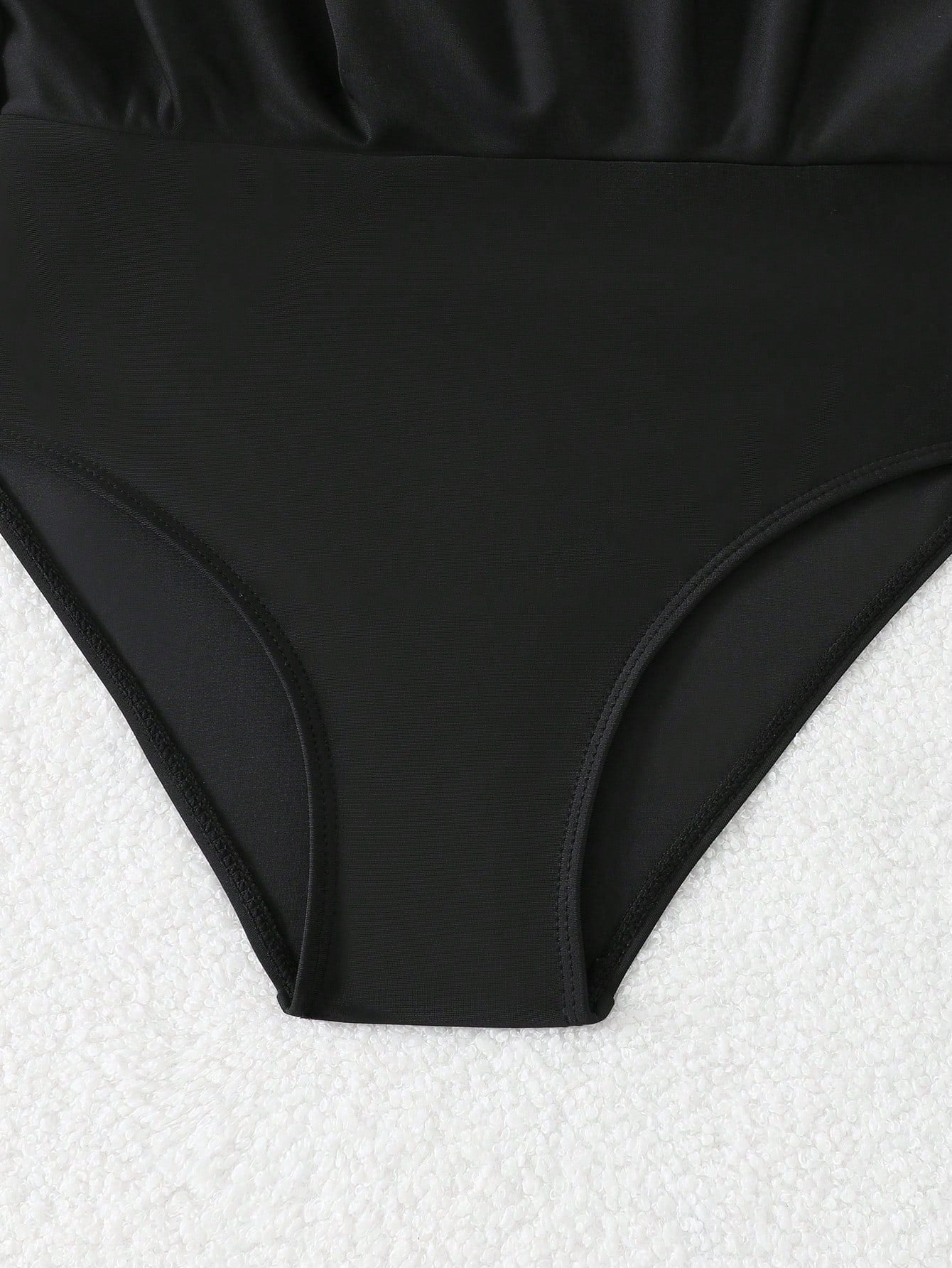 Tween girls one-piece swimsuit in black floral pattern with long sleeves, high neck, front zipper, and a skirt-style bottom.