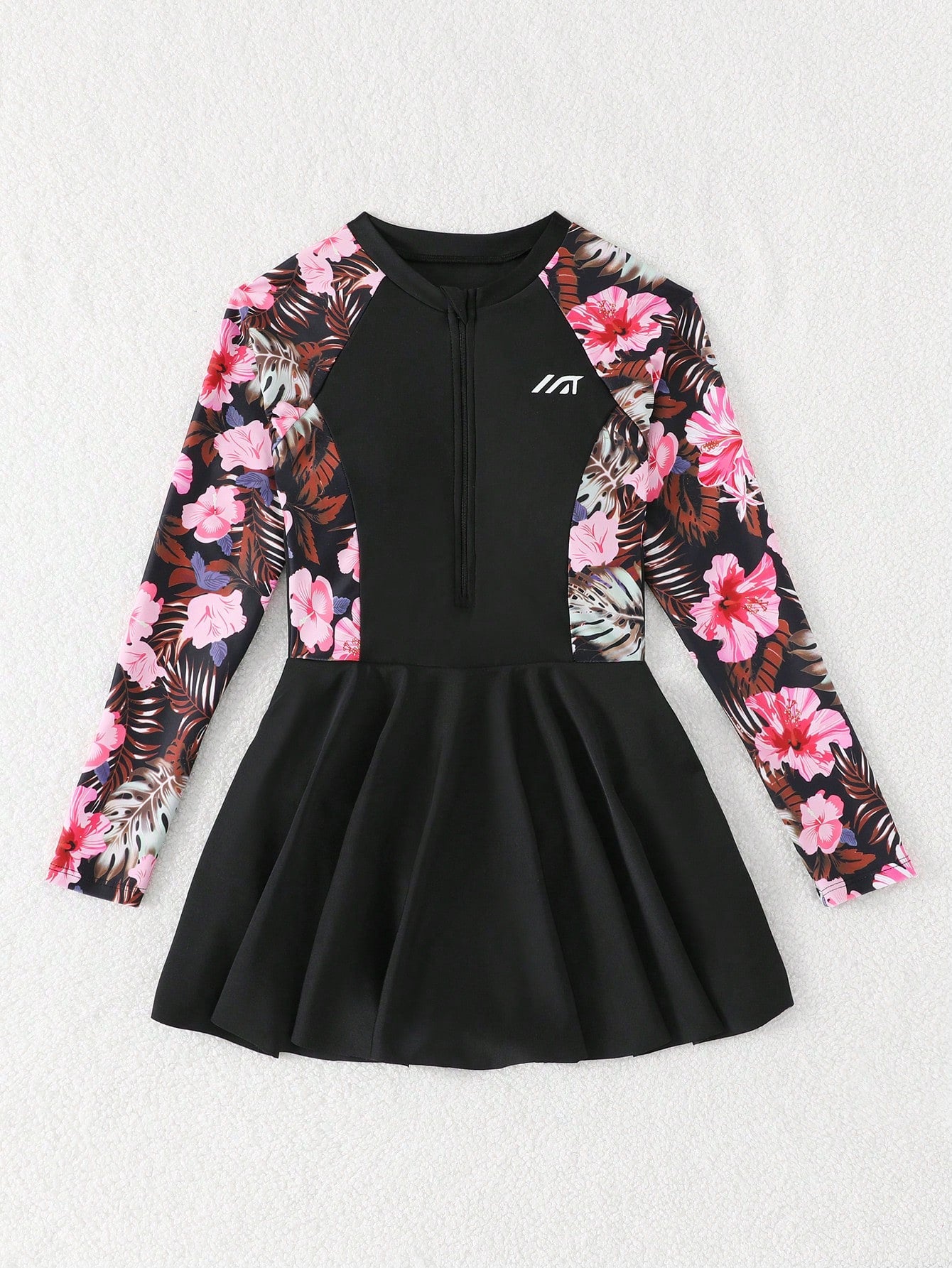 Tween girls one-piece swimsuit in black floral pattern with long sleeves, high neck, front zipper, and a skirt-style bottom.