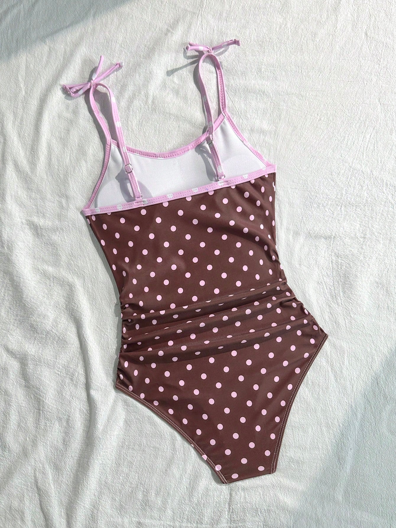 Tween girls' black and white one-piece swimsuit with striped patchwork design, scoop neck, asymmetrical cut-out detail, and fitted vacation swimwear style.