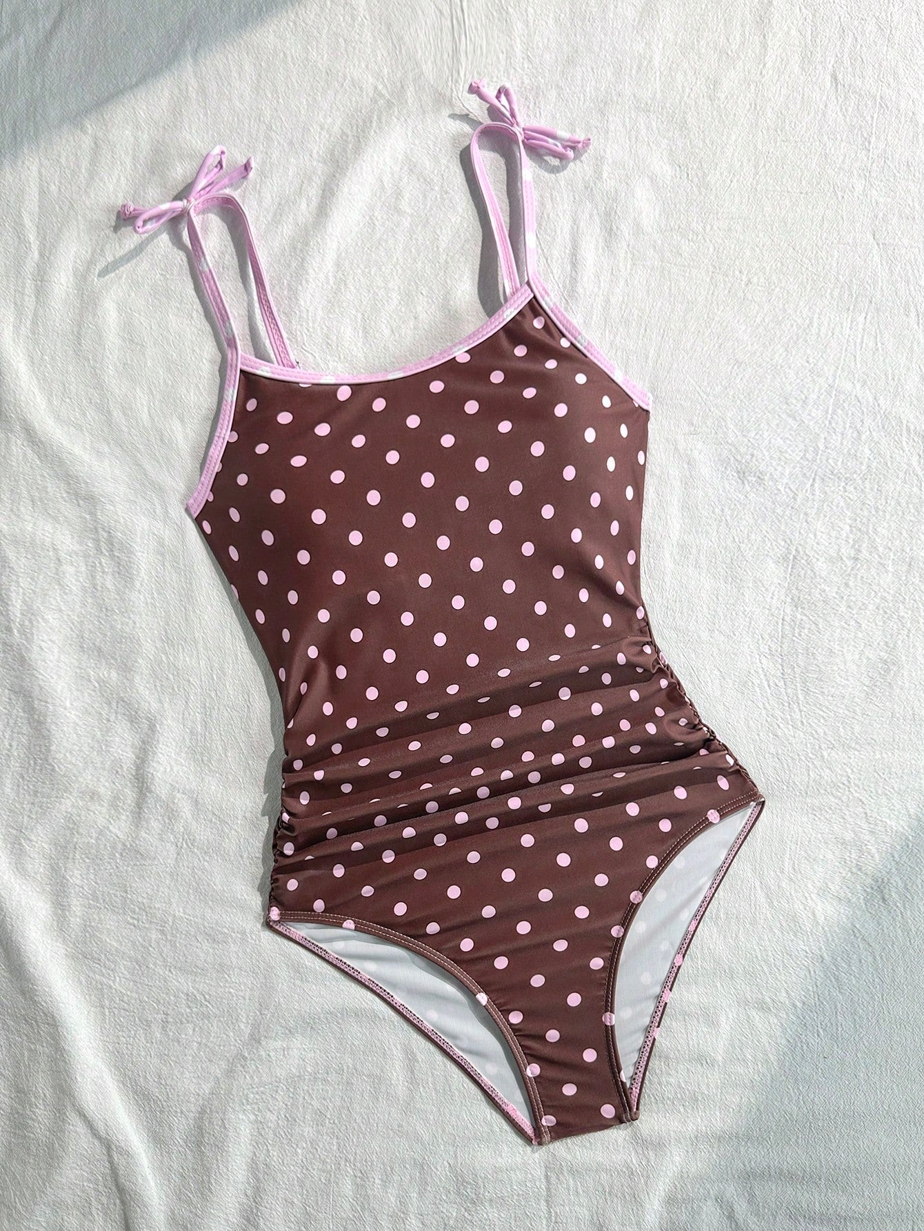Tween girls' black and white one-piece swimsuit with striped patchwork design, scoop neck, asymmetrical cut-out detail, and fitted vacation swimwear style.