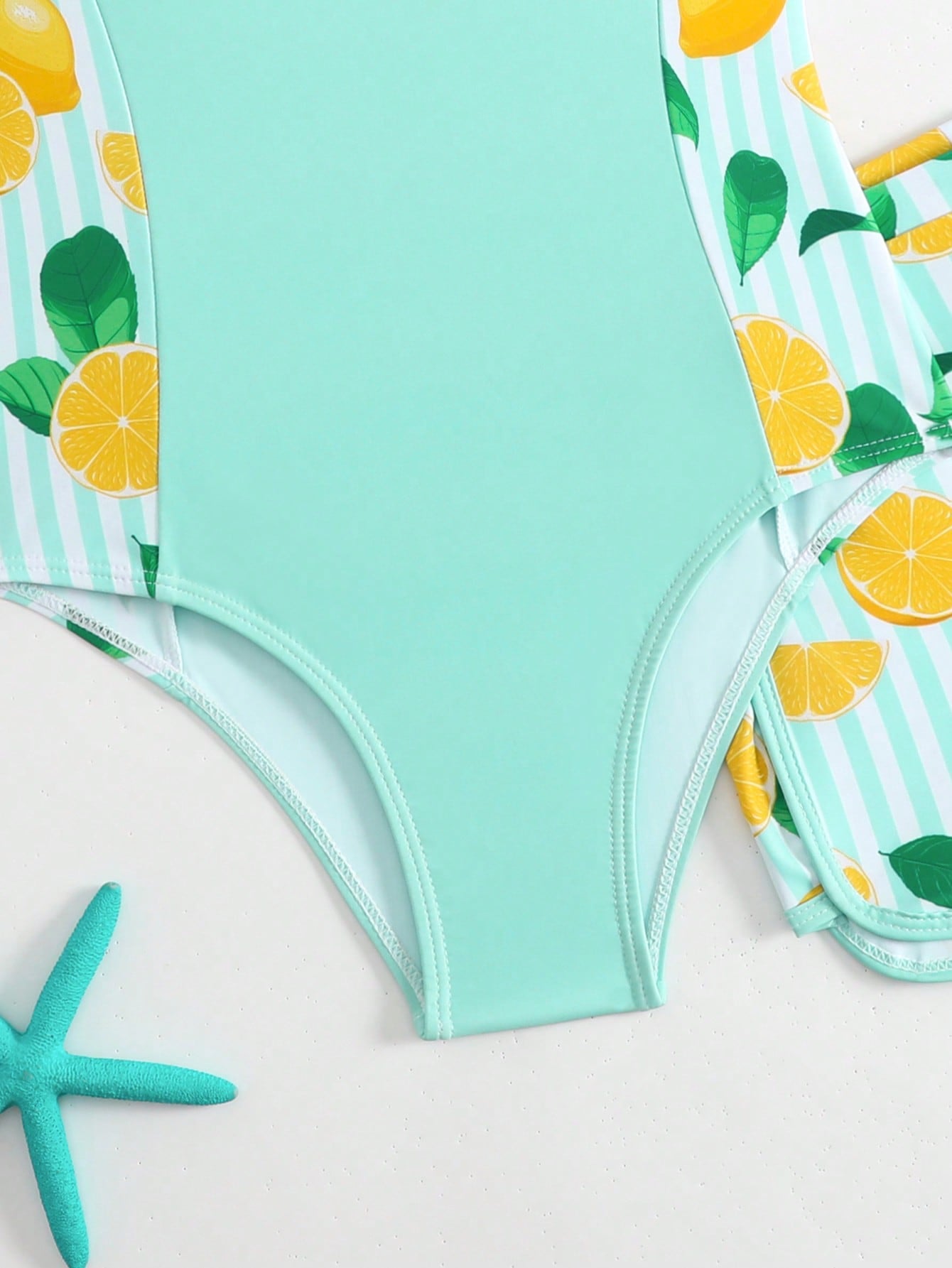 Tween girls 2-piece swimsuit set with a printed one-piece featuring ruffle trim, scoop neckline, cut-out detail, and matching shorts bottom.