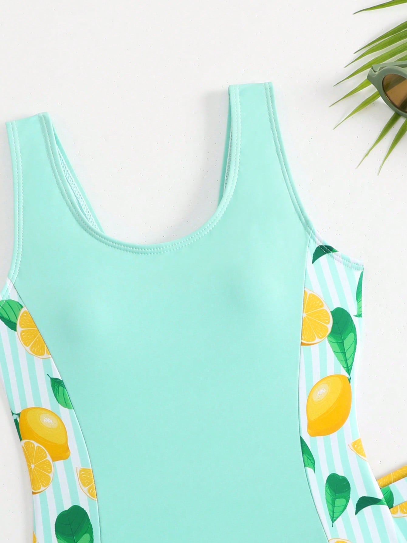 Tween girls 2-piece swimsuit set with a printed one-piece featuring ruffle trim, scoop neckline, cut-out detail, and matching shorts bottom.