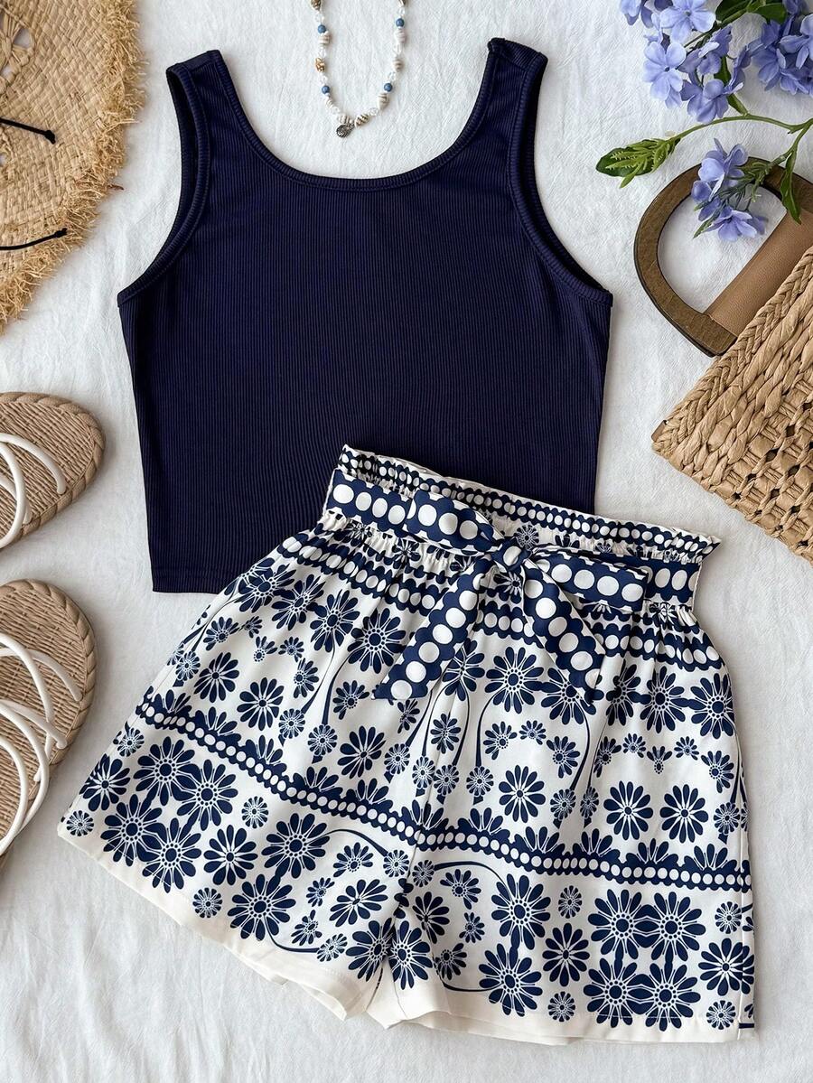 Tween girl summer two-piece outfit featuring a white scoop neck tank top and green ditsy floral print paperbag waist shorts with belt.