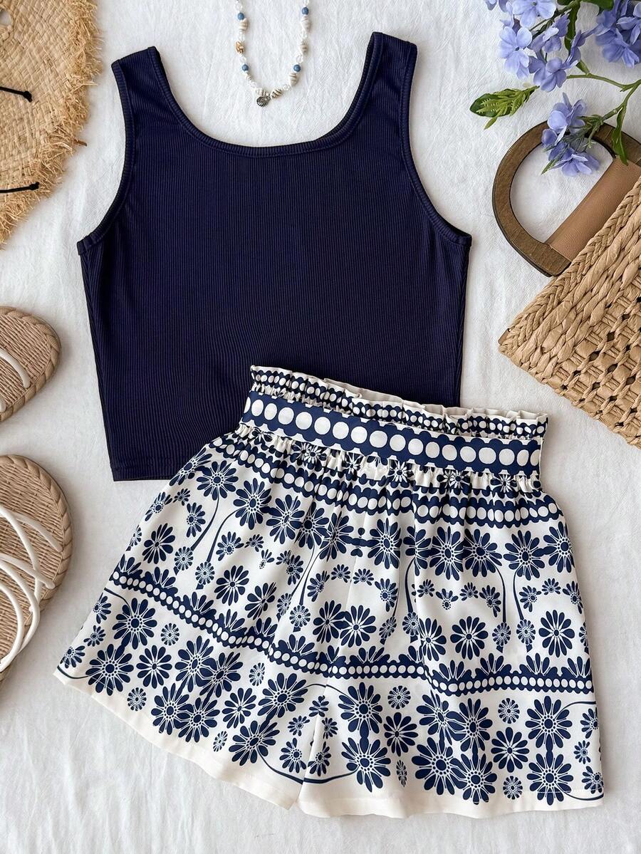 Tween girl summer two-piece outfit featuring a white scoop neck tank top and green ditsy floral print paperbag waist shorts with belt.