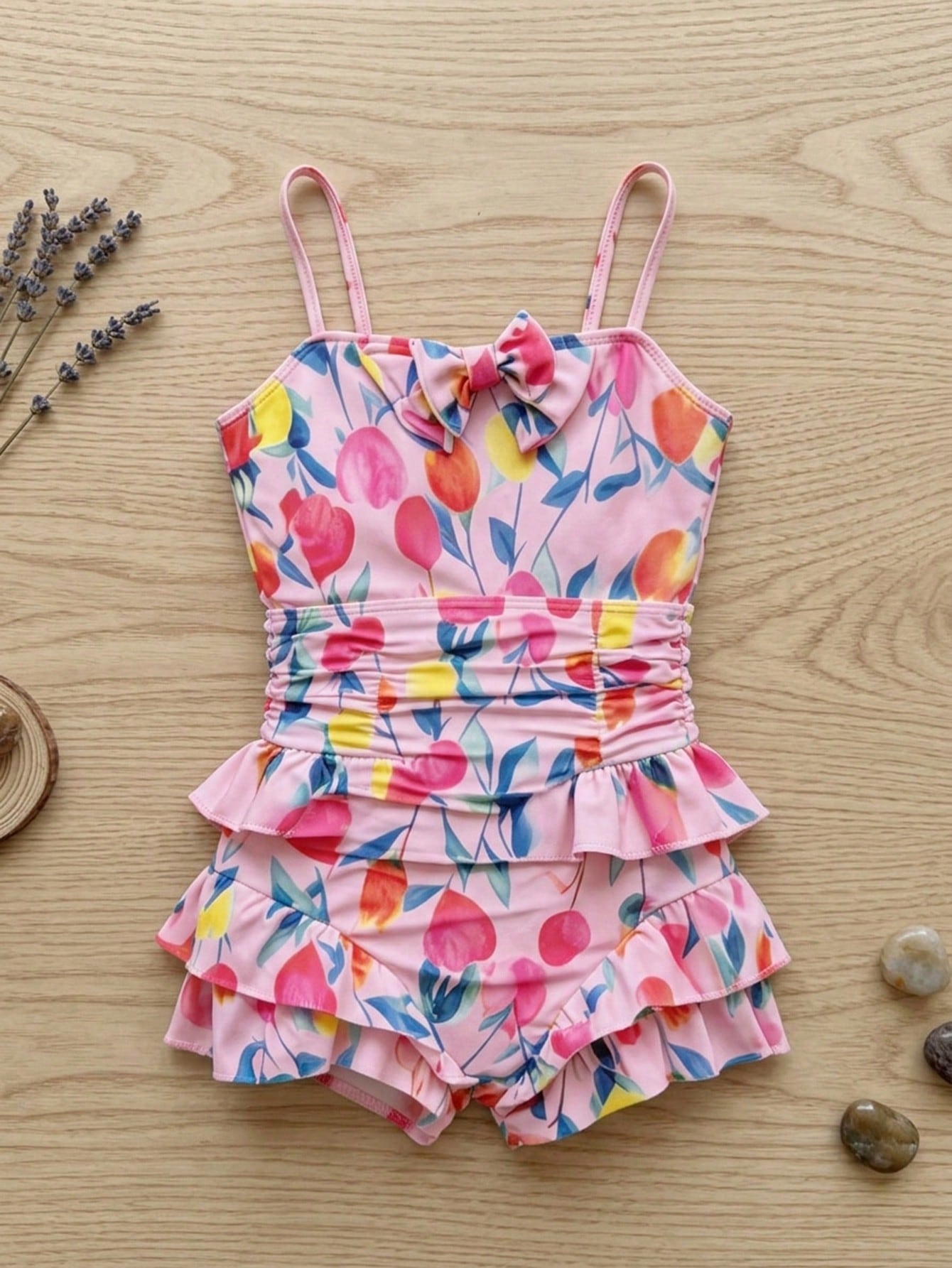 Pink one-piece swimsuit for tween girls with ruffle details, spaghetti straps, all-over print, and mid-waist bottom