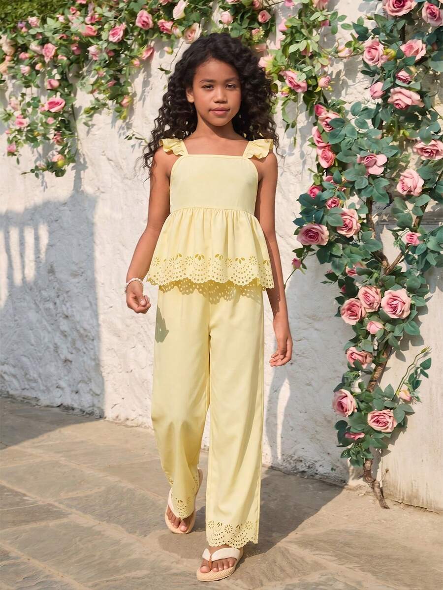 Tween girl wearing an apricot 2-piece outfit set featuring a shirred spaghetti strap short cami top and matching wide-leg long pants.