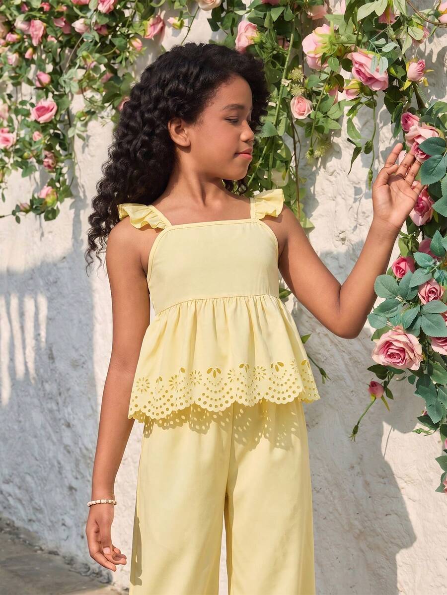 Tween girl wearing an apricot 2-piece outfit set featuring a shirred spaghetti strap short cami top and matching wide-leg long pants.