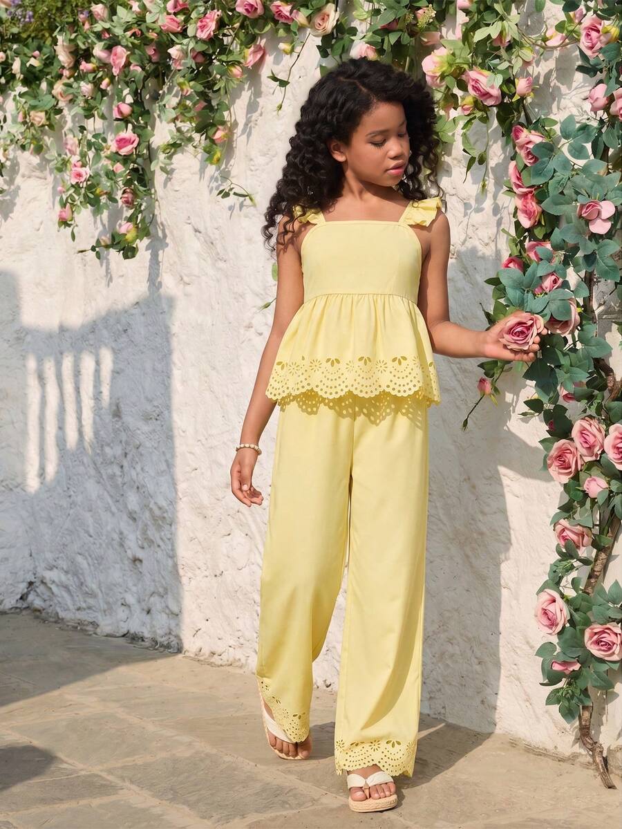 Tween girl wearing an apricot 2-piece outfit set featuring a shirred spaghetti strap short cami top and matching wide-leg long pants.