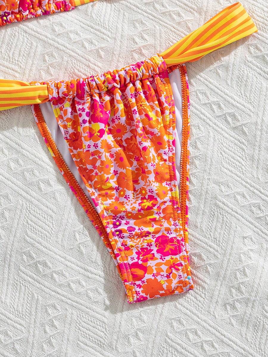Women's striped halter two-piece swimsuit featuring a lace-up triangle top with removable padding and high-cut low-waist bikini bottoms.