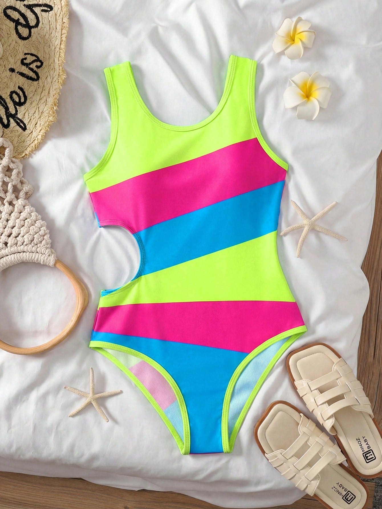 Tween girls' black and white one-piece swimsuit with striped patchwork design, scoop neck, asymmetrical cut-out detail, and fitted vacation swimwear style.