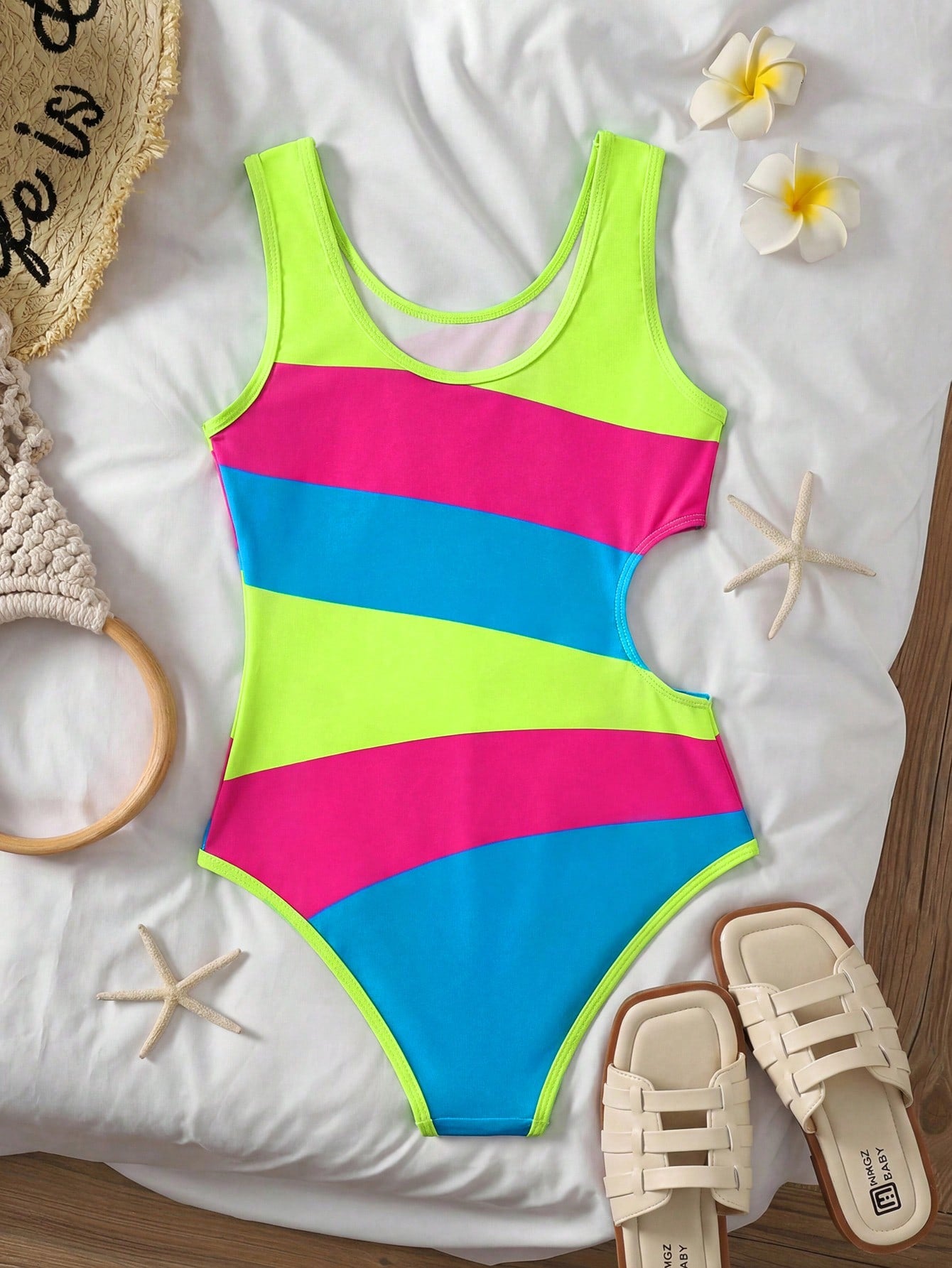 Tween girls' black and white one-piece swimsuit with striped patchwork design, scoop neck, asymmetrical cut-out detail, and fitted vacation swimwear style.