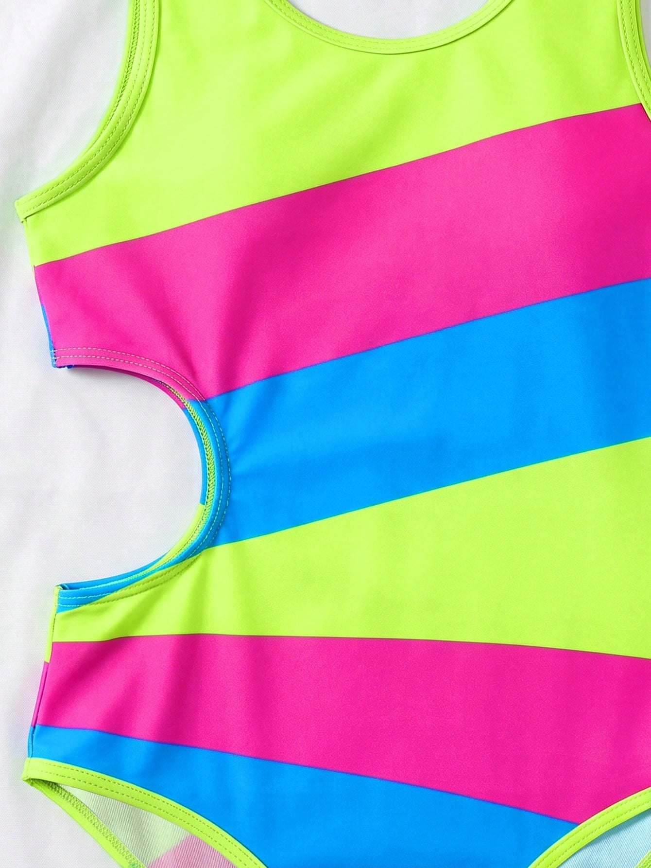 Tween girls' black and white one-piece swimsuit with striped patchwork design, scoop neck, asymmetrical cut-out detail, and fitted vacation swimwear style.