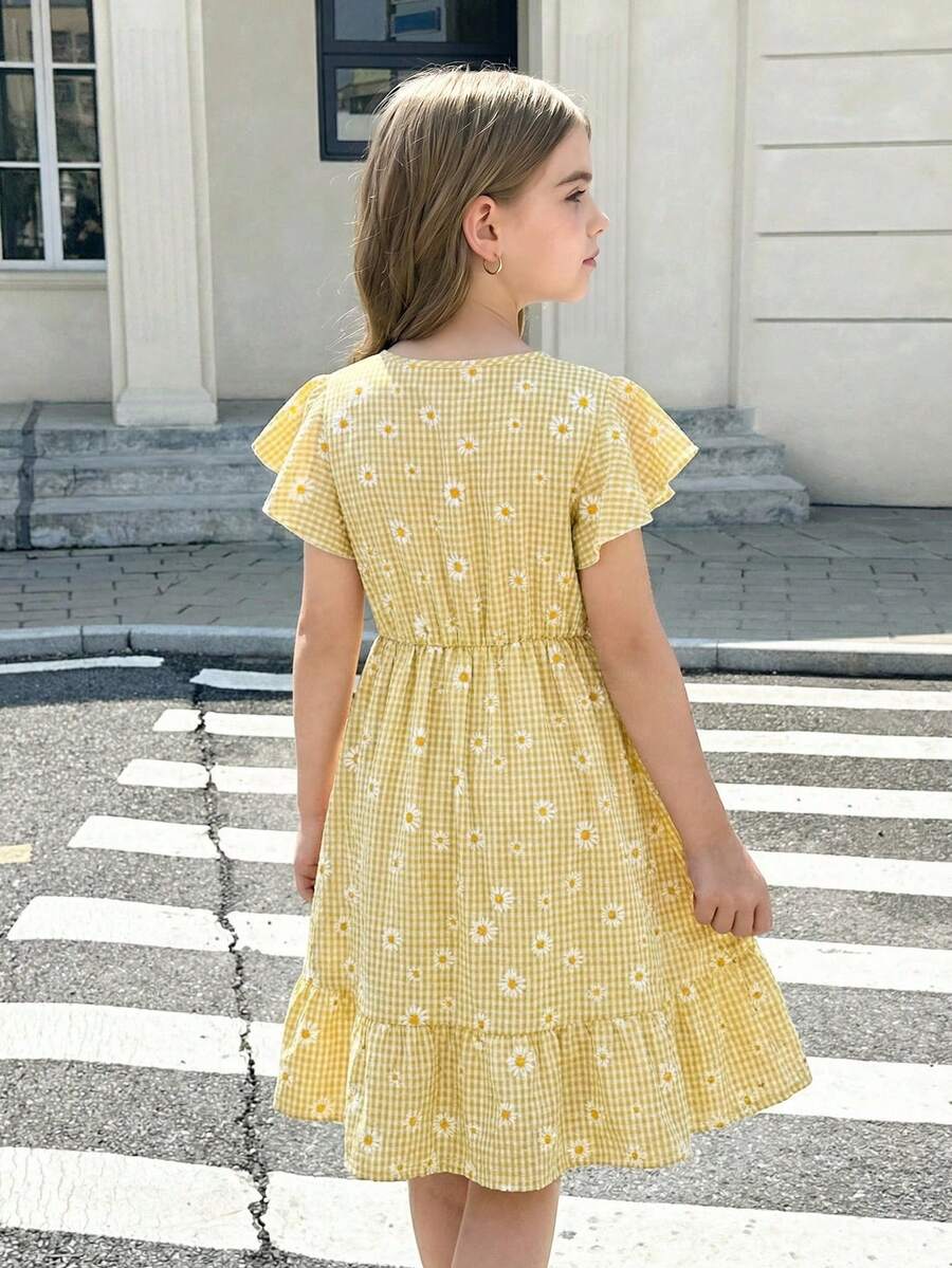Tween girl wearing a black ditsy floral A-line short dress with V-neckline and flounce short sleeves.