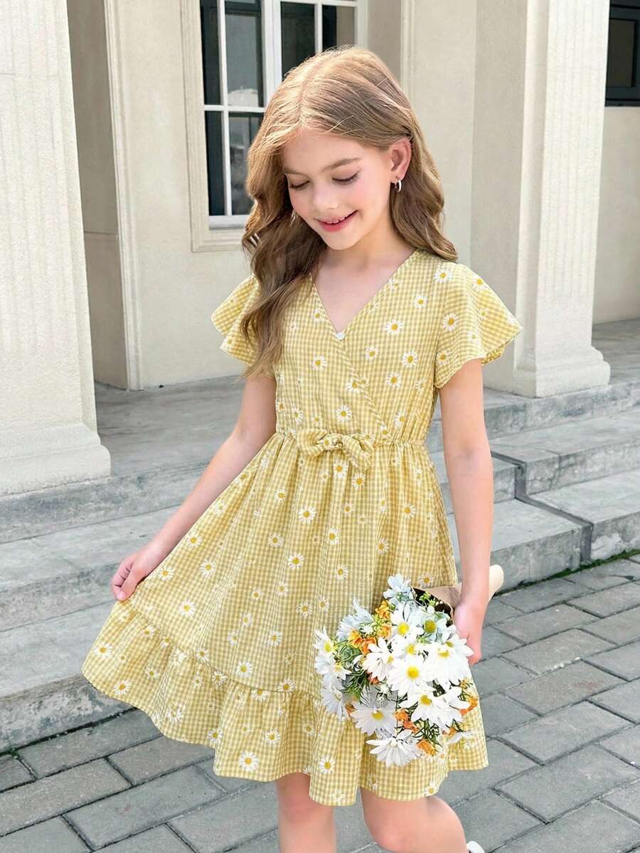 Tween girl wearing a black ditsy floral A-line short dress with V-neckline and flounce short sleeves.