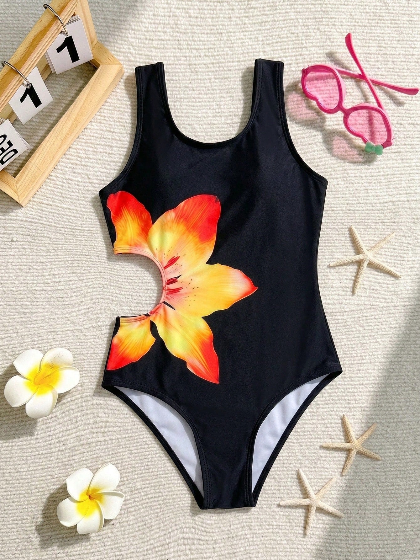 Tween girls' black and white one-piece swimsuit with striped patchwork design, scoop neck, asymmetrical cut-out detail, and fitted vacation swimwear style.