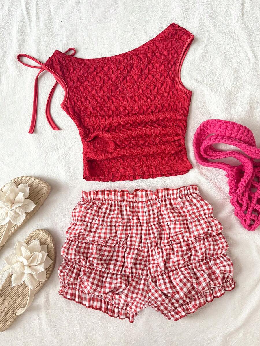 Tween girl wearing a casual 2-piece set featuring a black rib-knit scoop neck tank top and leopard print paperbag waist shorts with a matching belt.