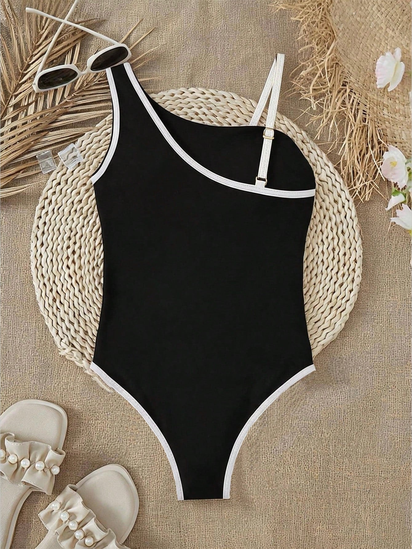 Tween girl one-piece swimsuit in brown polka dot geometric print with asymmetrical neckline, ruffle detail, cut-out design, and fitted mid-waist swim bottom.
