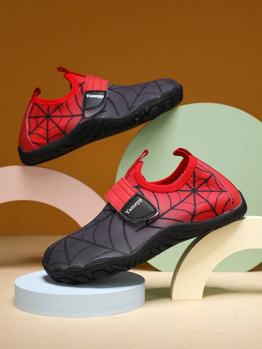 Black kids water shoes featuring a spider web graphic design, fabric upper, hook loop closure, and non-slip rubber outsole.