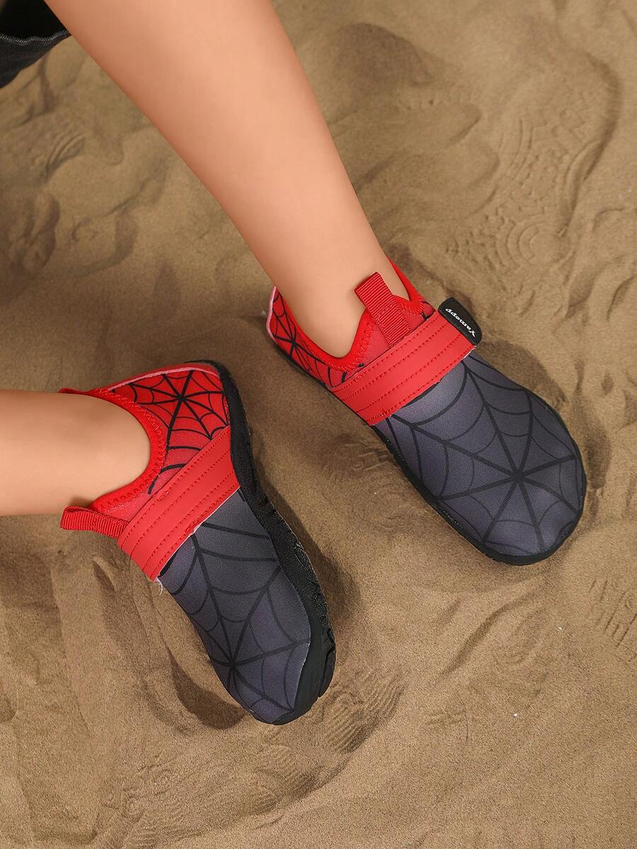 Black kids water shoes featuring a spider web graphic design, fabric upper, hook loop closure, and non-slip rubber outsole.
