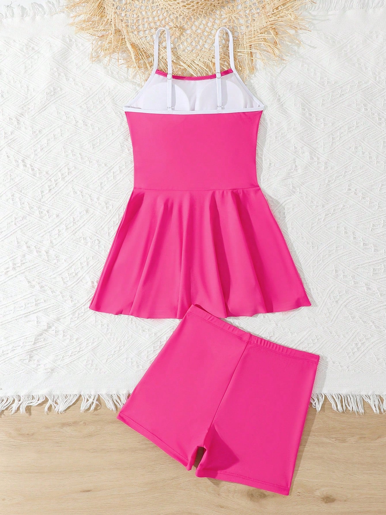 Tween girls black two-piece tankini swimwear set featuring a spaghetti strap sleeveless top with cutout detail and contrast piping, paired with short swim shorts.