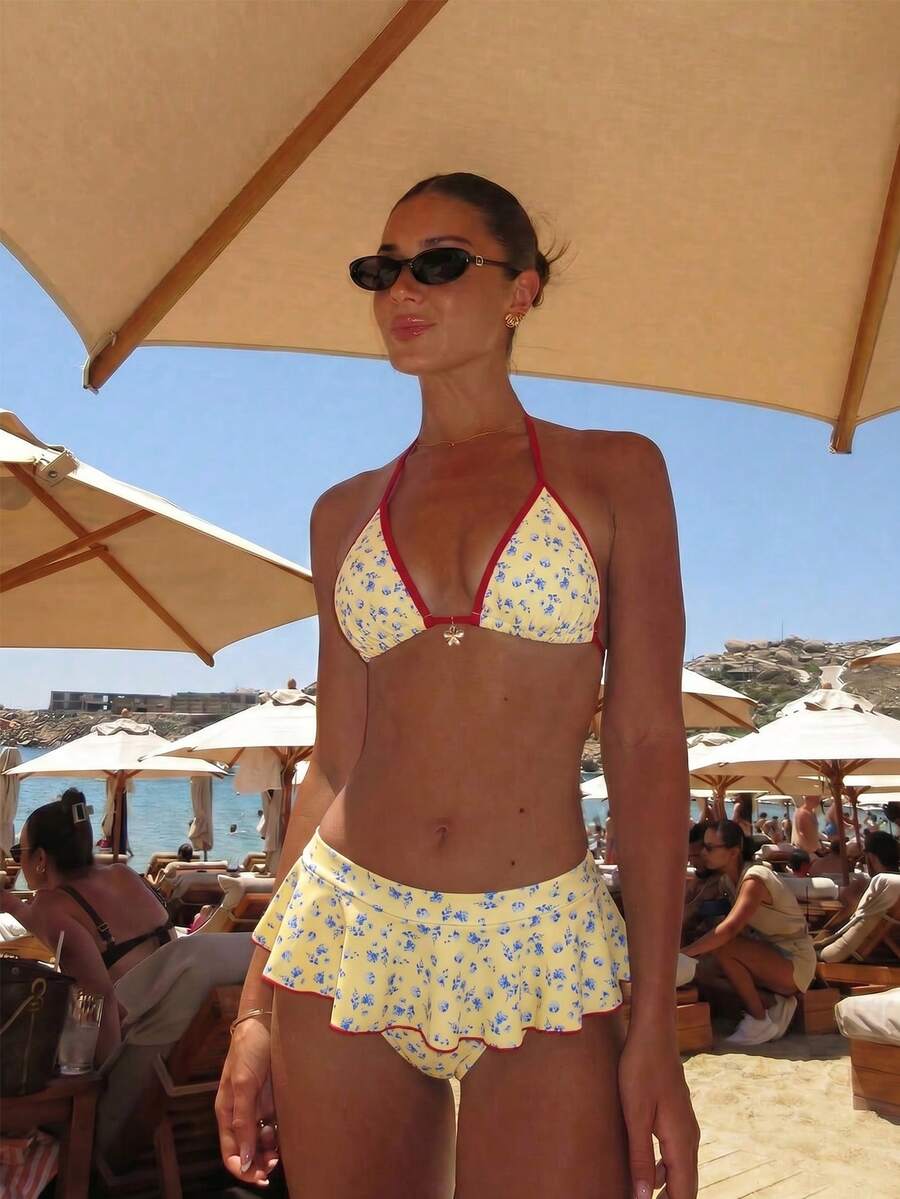 Women's 70s retro black and white polka dot bikini set featuring a halter triangle top and ultra low waist bottoms.