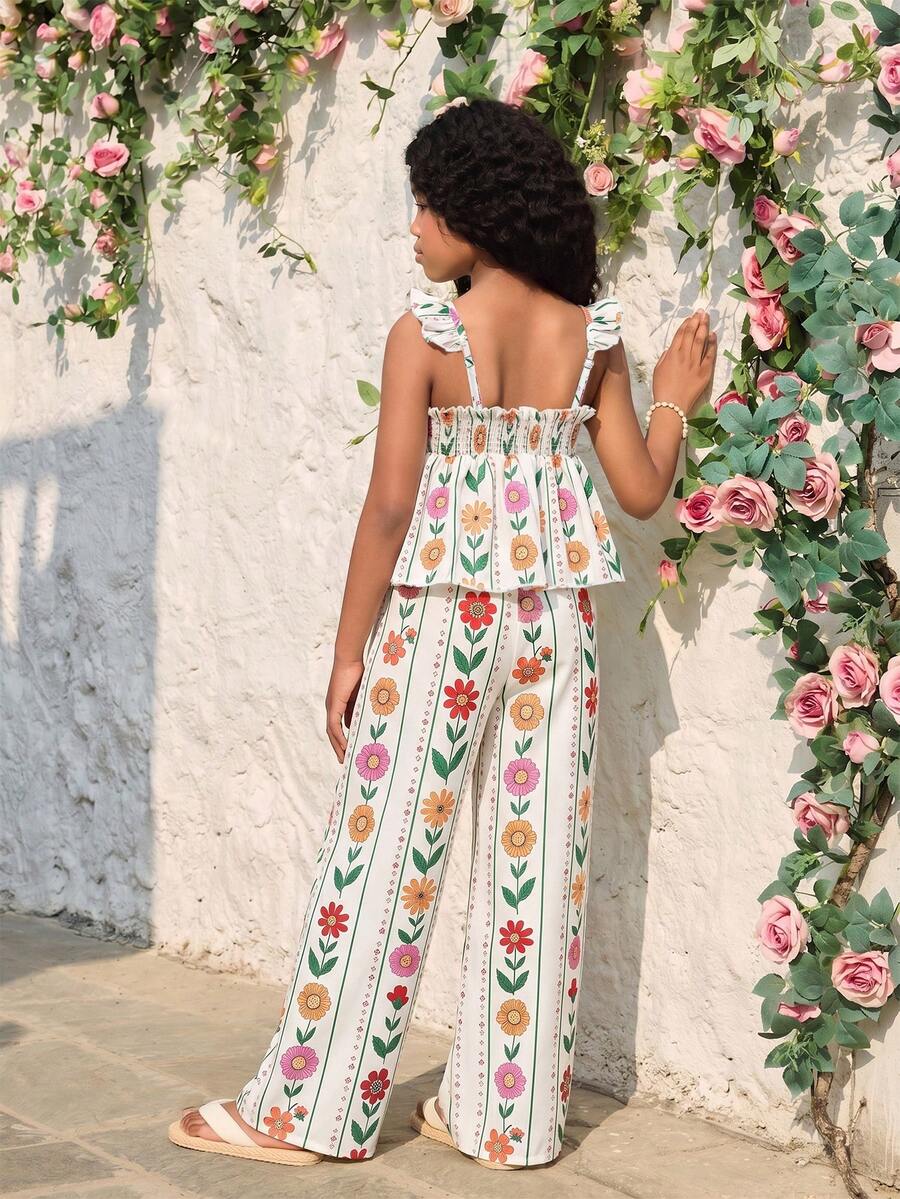 Tween girl wearing an apricot 2-piece outfit set featuring a shirred spaghetti strap short cami top and matching wide-leg long pants.