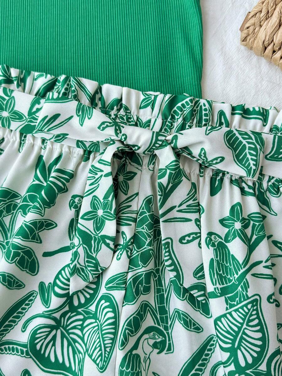 Tween girl summer two-piece outfit featuring a white scoop neck tank top and green ditsy floral print paperbag waist shorts with belt.
