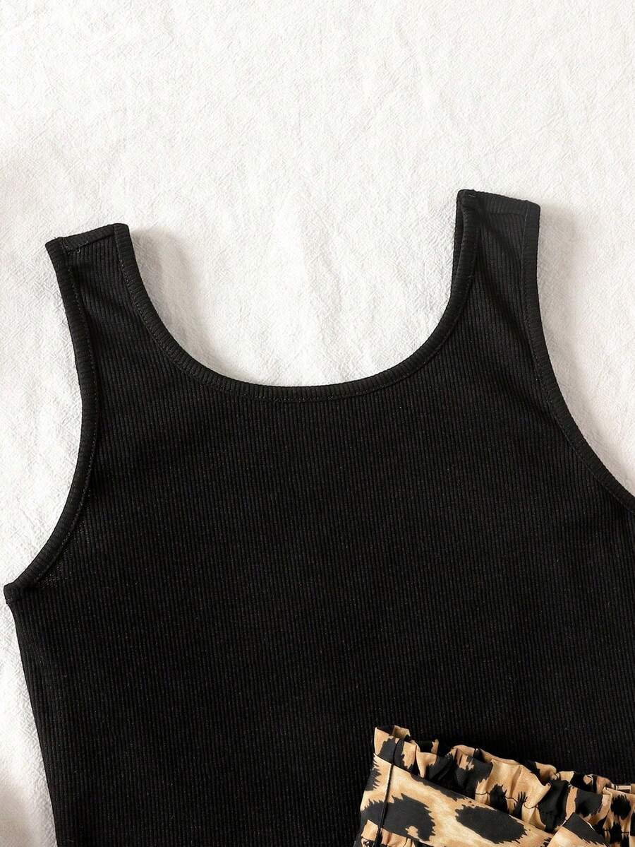 Tween girl wearing a casual 2-piece set featuring a black rib-knit scoop neck tank top and leopard print paperbag waist shorts with a matching belt.
