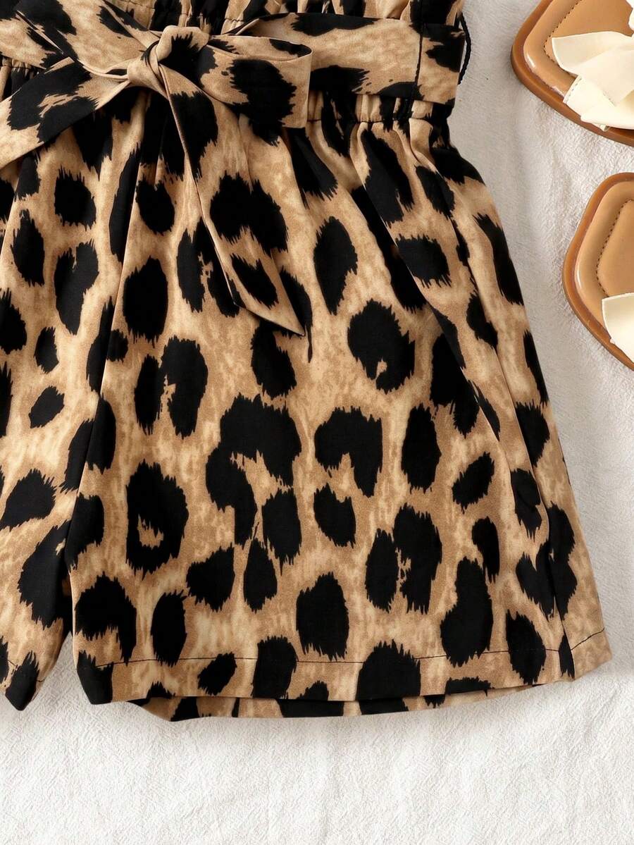 Tween girl wearing a casual 2-piece set featuring a black rib-knit scoop neck tank top and leopard print paperbag waist shorts with a matching belt.