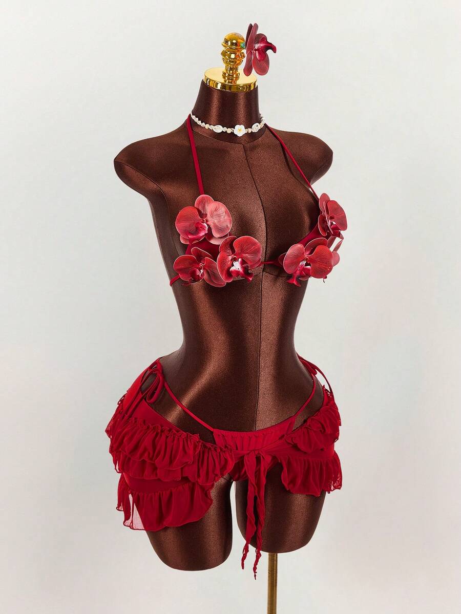 Women's 3-piece blue bikini swimwear set featuring a crop top with 3D rose accents, tie back detail, spaghetti straps, and tie-side bottoms.