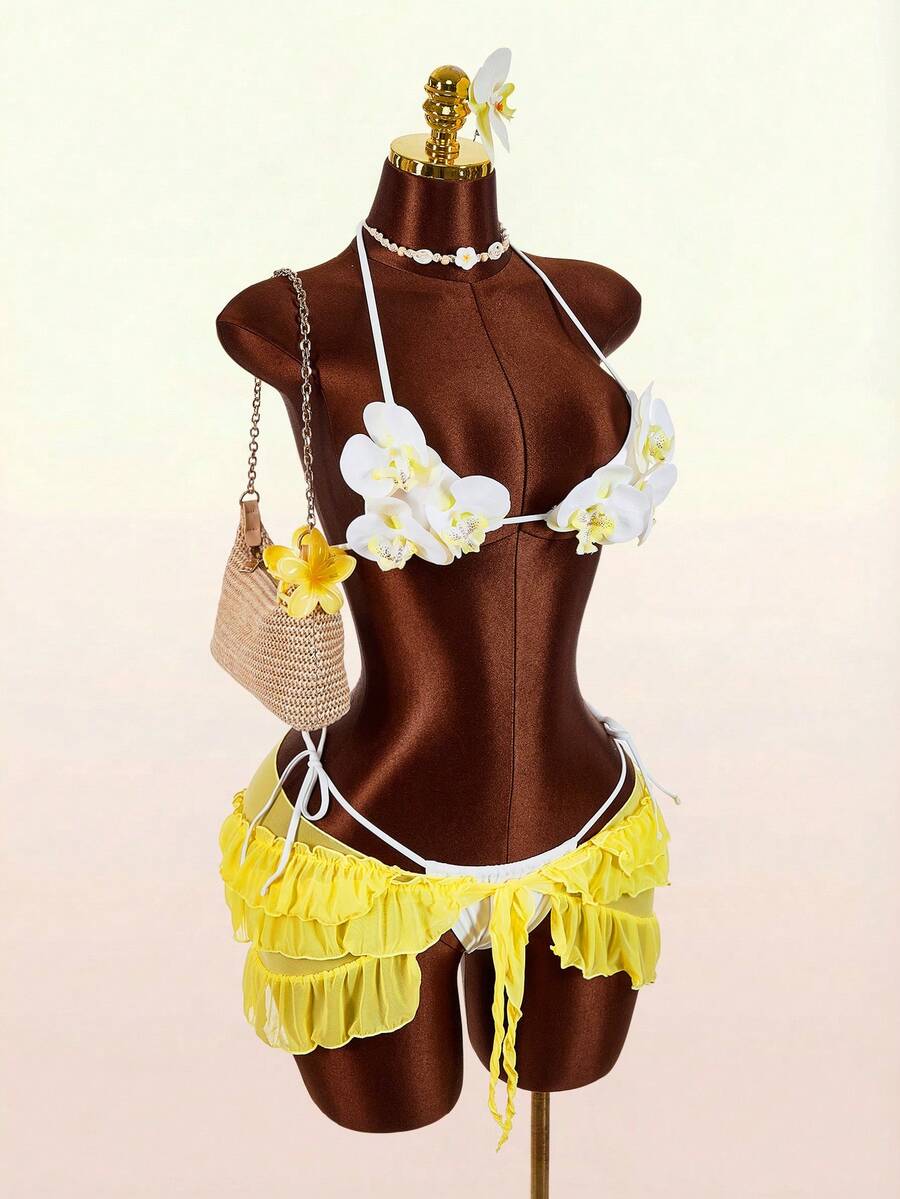 Women's 3-piece blue bikini swimwear set featuring a crop top with 3D rose accents, tie back detail, spaghetti straps, and tie-side bottoms.