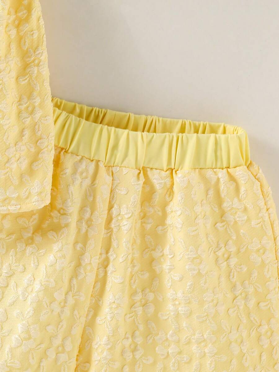 Tween girl wearing a blue and white striped sleeveless top featuring embroidery details and ruffle trim with matching shorts.