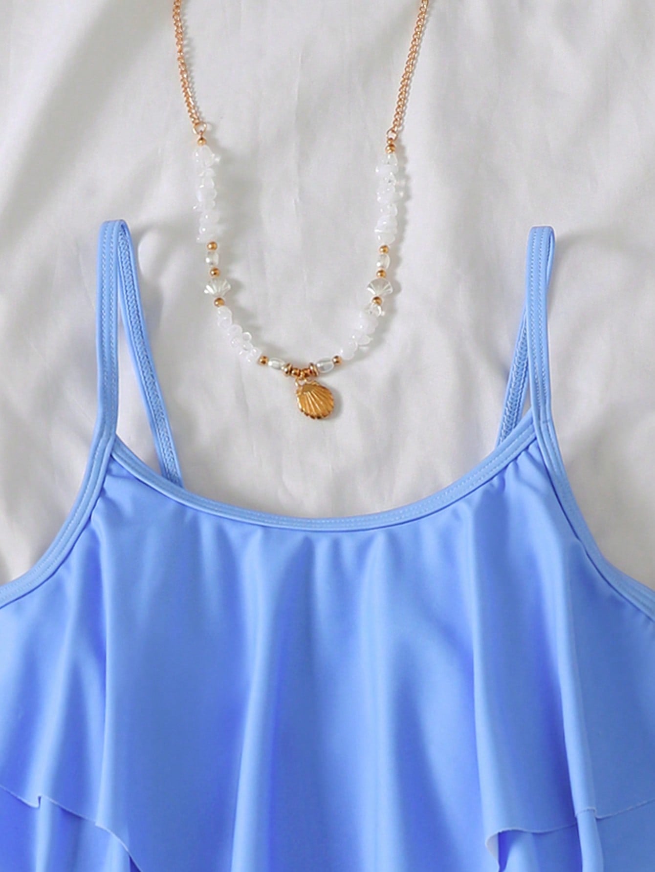 NEWSHEIN tween girls fitted one-piece swimsuit in blue and white plant pattern with ruffle tiered detail, spaghetti straps, and lined body for beach or resort wear